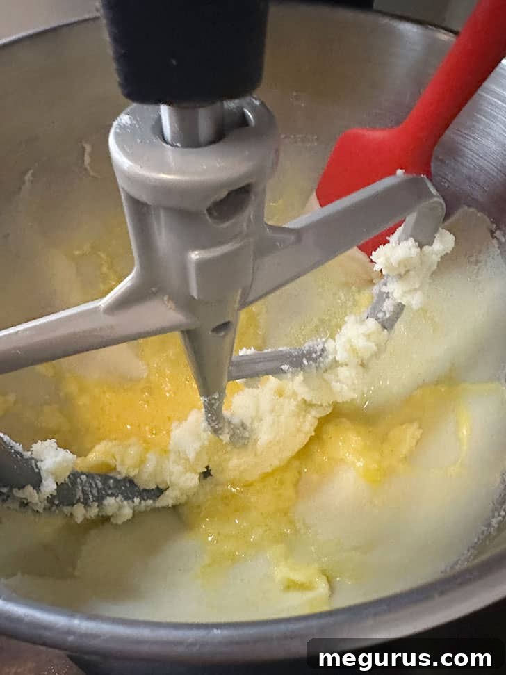 Scraping down the sides of the mixing bowl.