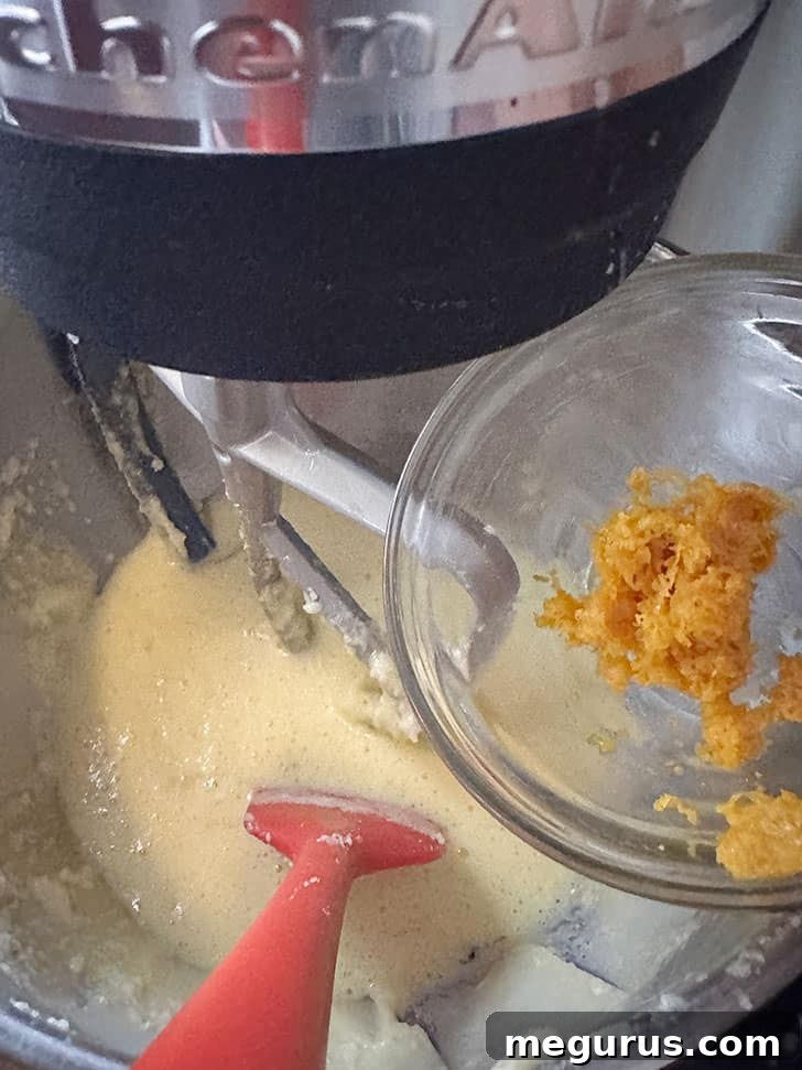 Adding fresh orange zest to the batter.