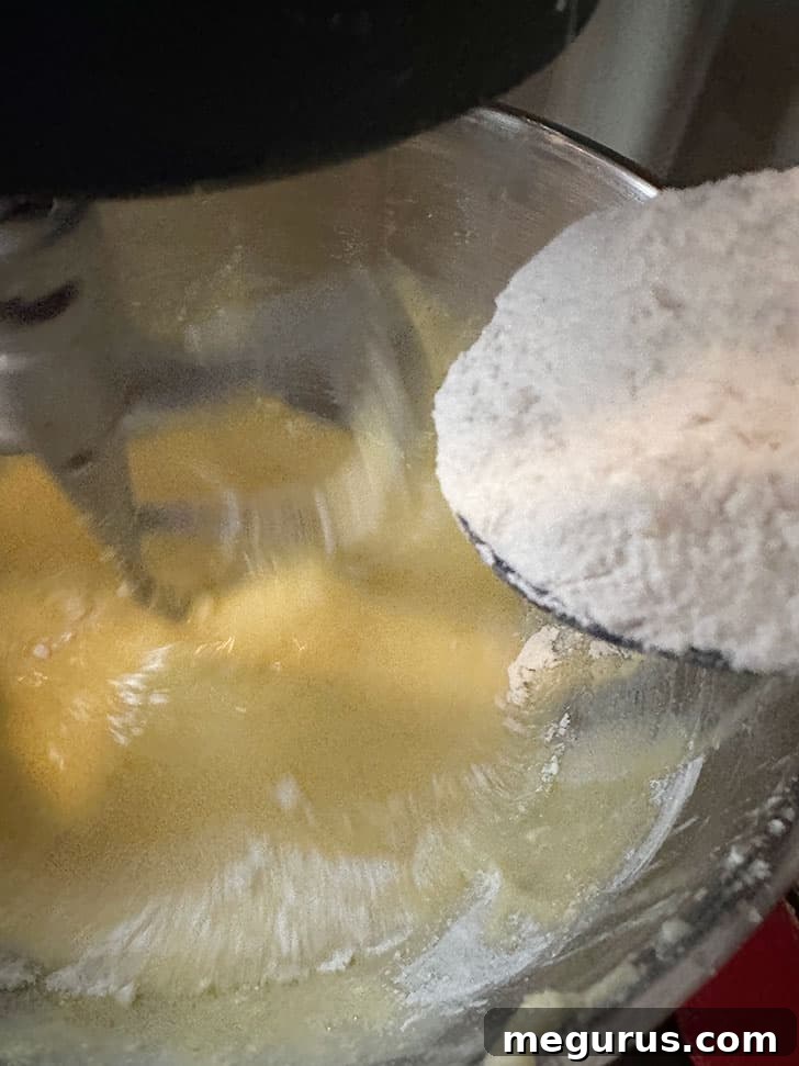 Gradually adding the dry flour mixture.