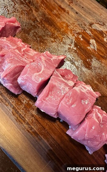 Pork tenderloin sliced into uniform medallions, ready for cooking.