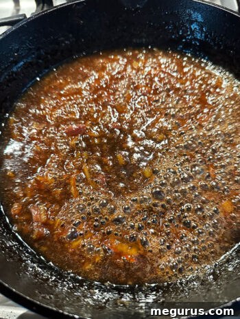 The orange ginger sauce simmering and thickening in the skillet to a syrupy consistency.