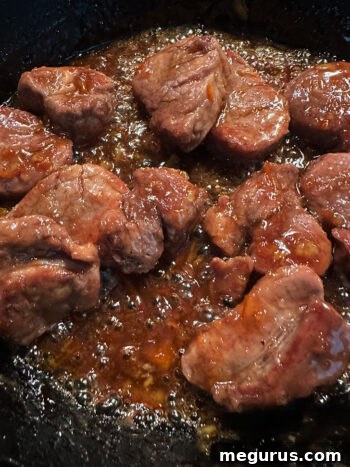 Pork medallions returned to the skillet, coated in the glistening, hot ginger-orange glaze.