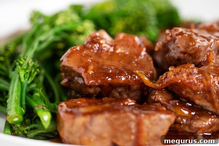 Ginger Orange Pork Medallions on a plate with broccolini, showcasing the vibrant sauce.