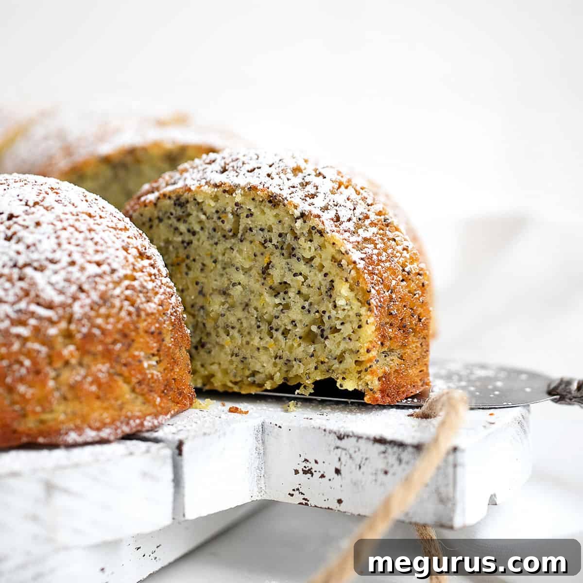 Orange Poppy Seed Bundt Cake sliced on white board
