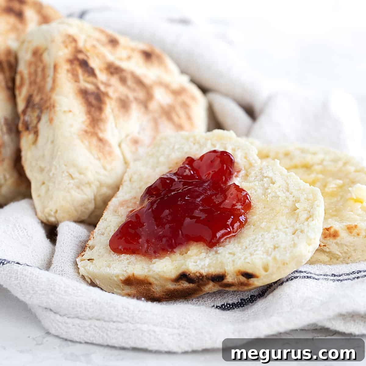 Irish soda farls, freshly cooked in a dry skillet, split open and served with butter and jam on a tea towel.