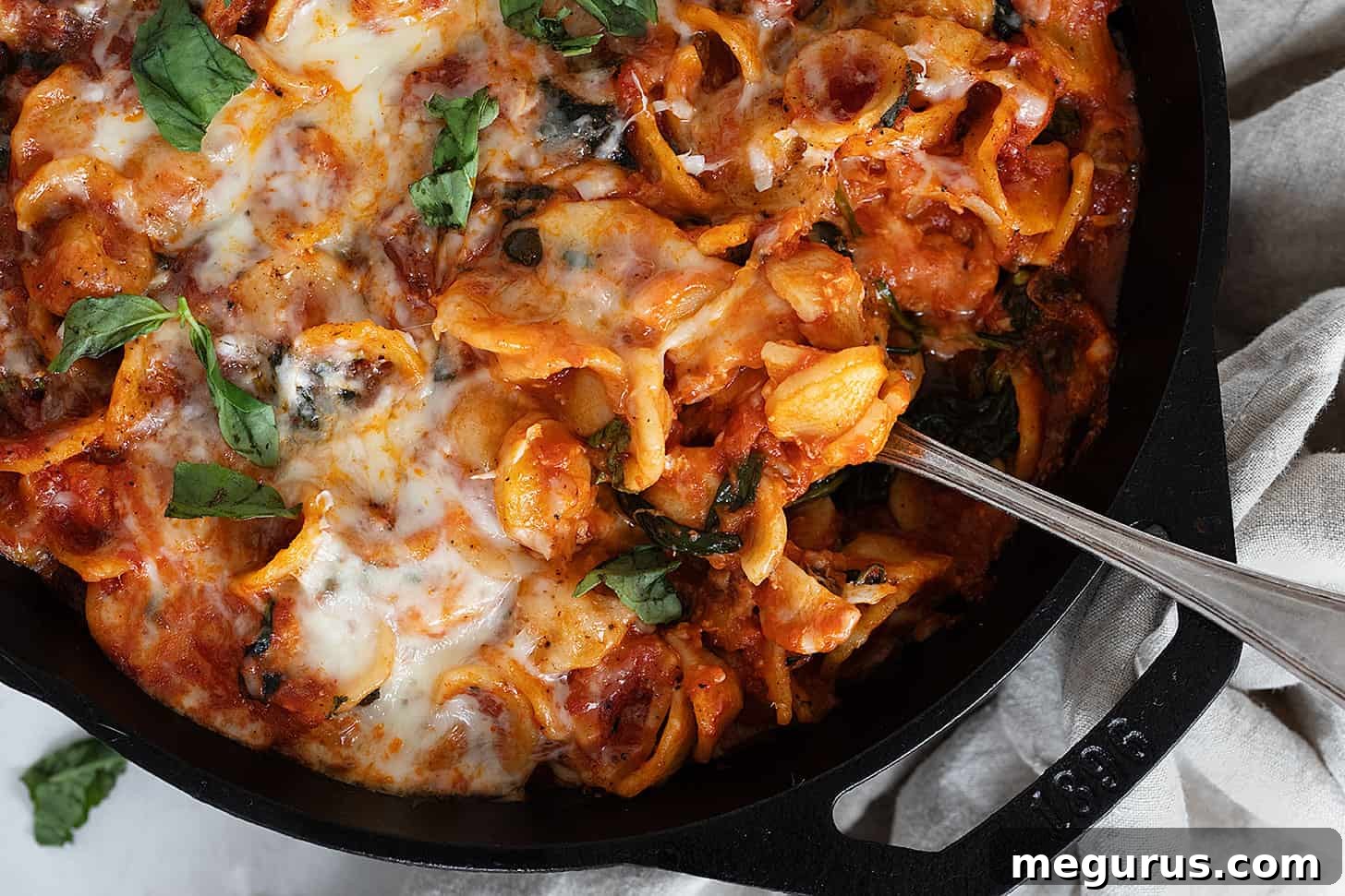 cheesy orecchietta in cast iron skillet with spoon