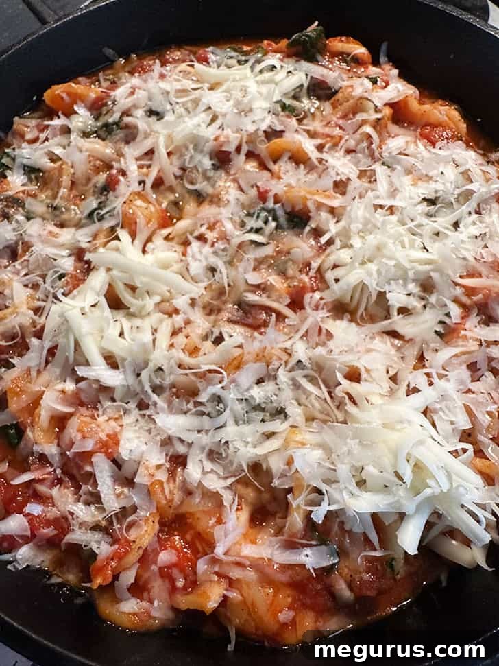 skillet topped with cheese and ready to bake.