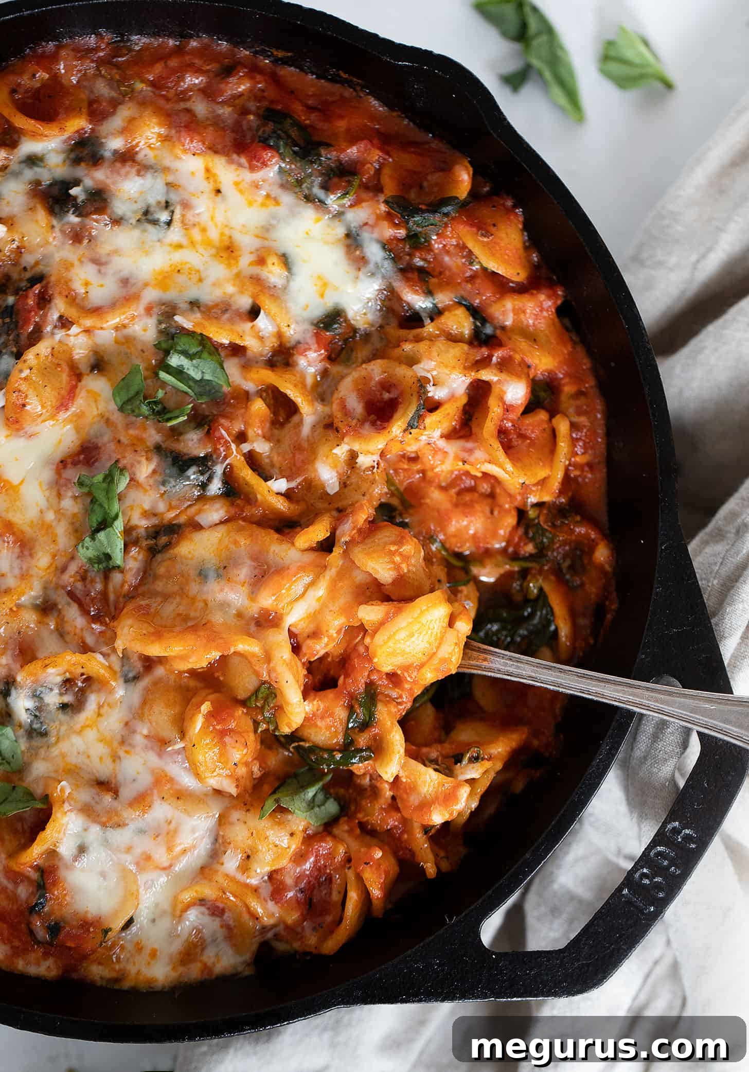 cheesy orecchiette in skillet with spoon