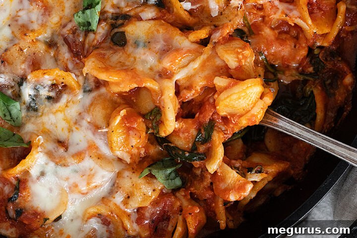 cheesy orecchietta in cast iron skillet with spoon