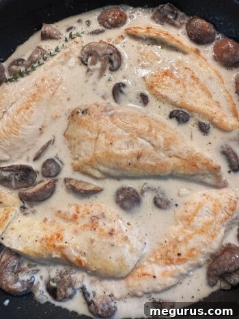 Returning browned chicken pieces to the creamy sauce in the pan