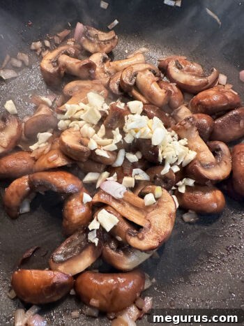 Chopped garlic added to the mushroom and shallot mixture in the pan