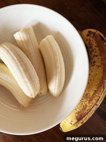 Yellow spotted bananas in a bowl, ready to be mashed for the muffin batter.