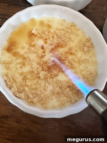 Torching sugar topping on crème brûlée