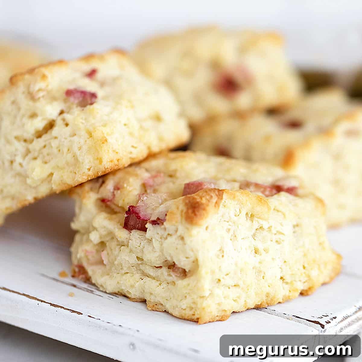 Delicious rhubarb scones on a white serving board, perfect for breakfast or tea time.