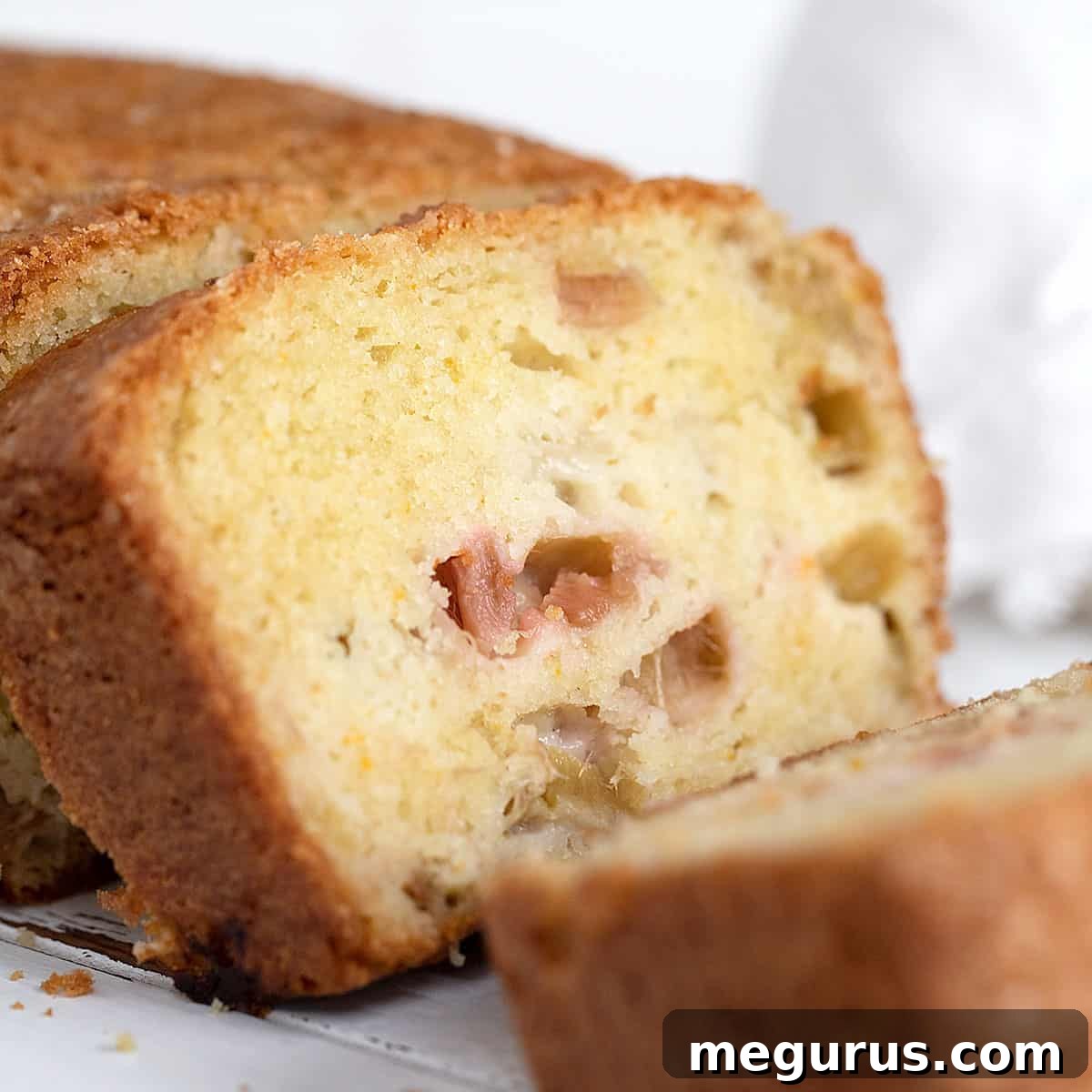Slices of a moist rhubarb loaf with a crunchy exterior.