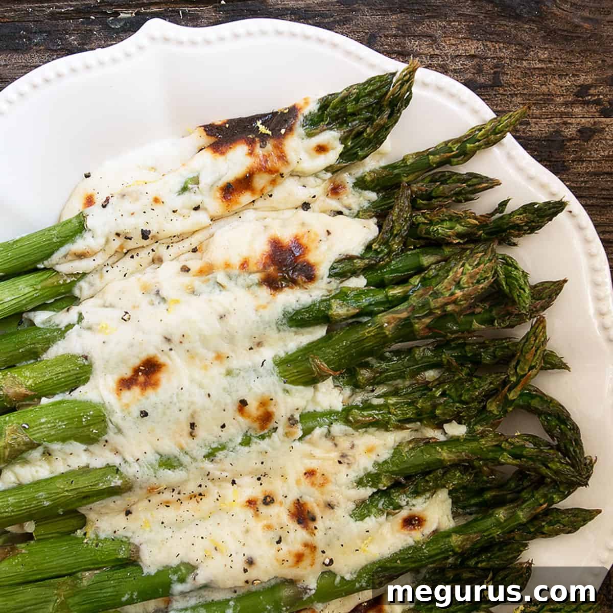 Asparagus cacio e pepe on a white serving platter.