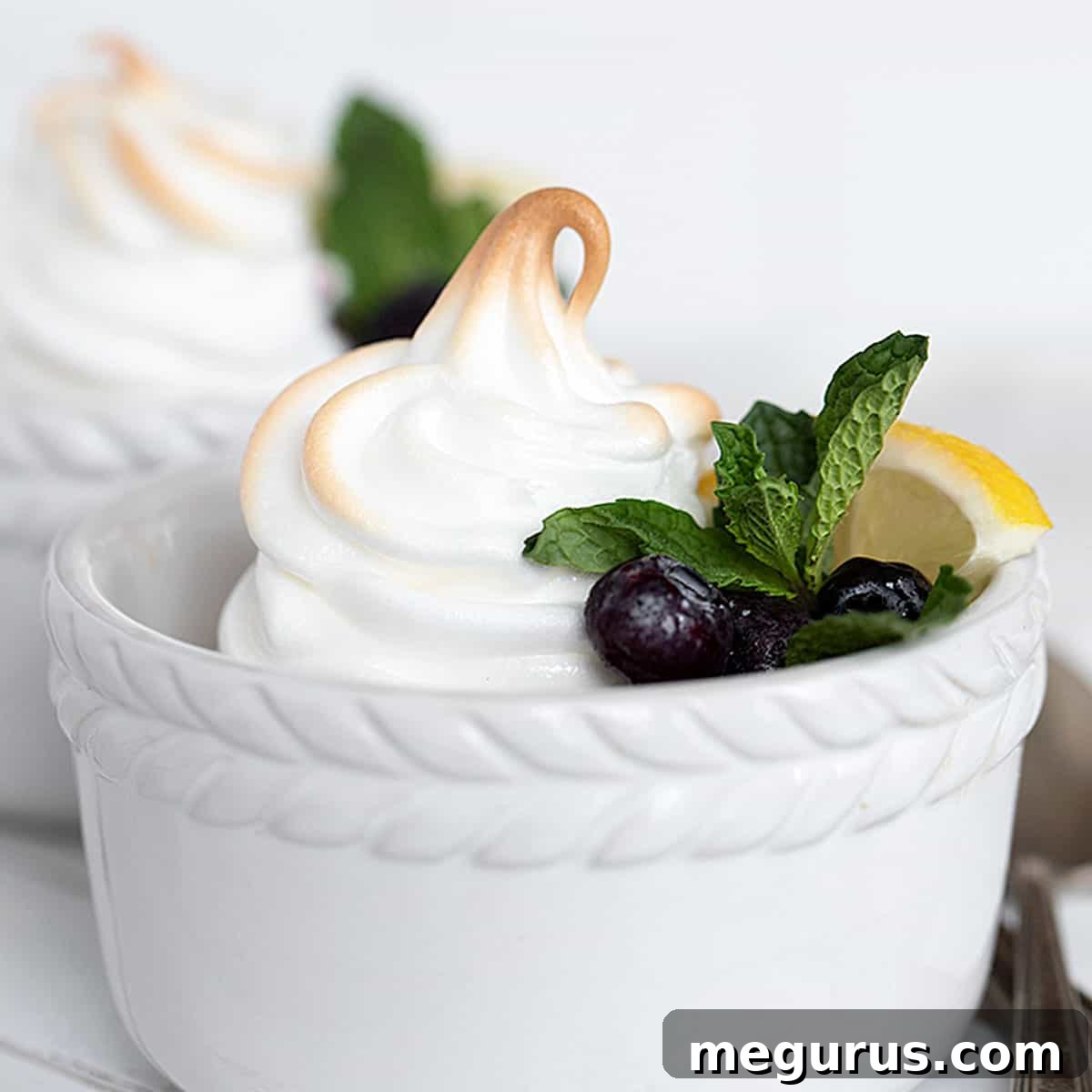 lemon meringue pudding in white ramekins with blueberries