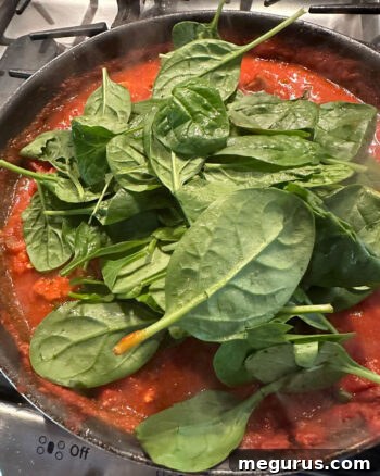 adding spinach to skillet
