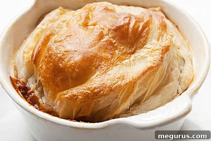 Close-up of a slice of Beef and Guinness Pot Pie showing tender beef and rich gravy