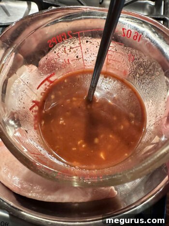 A bowl of sticky chicken glaze ingredients mixed and ready to pour.