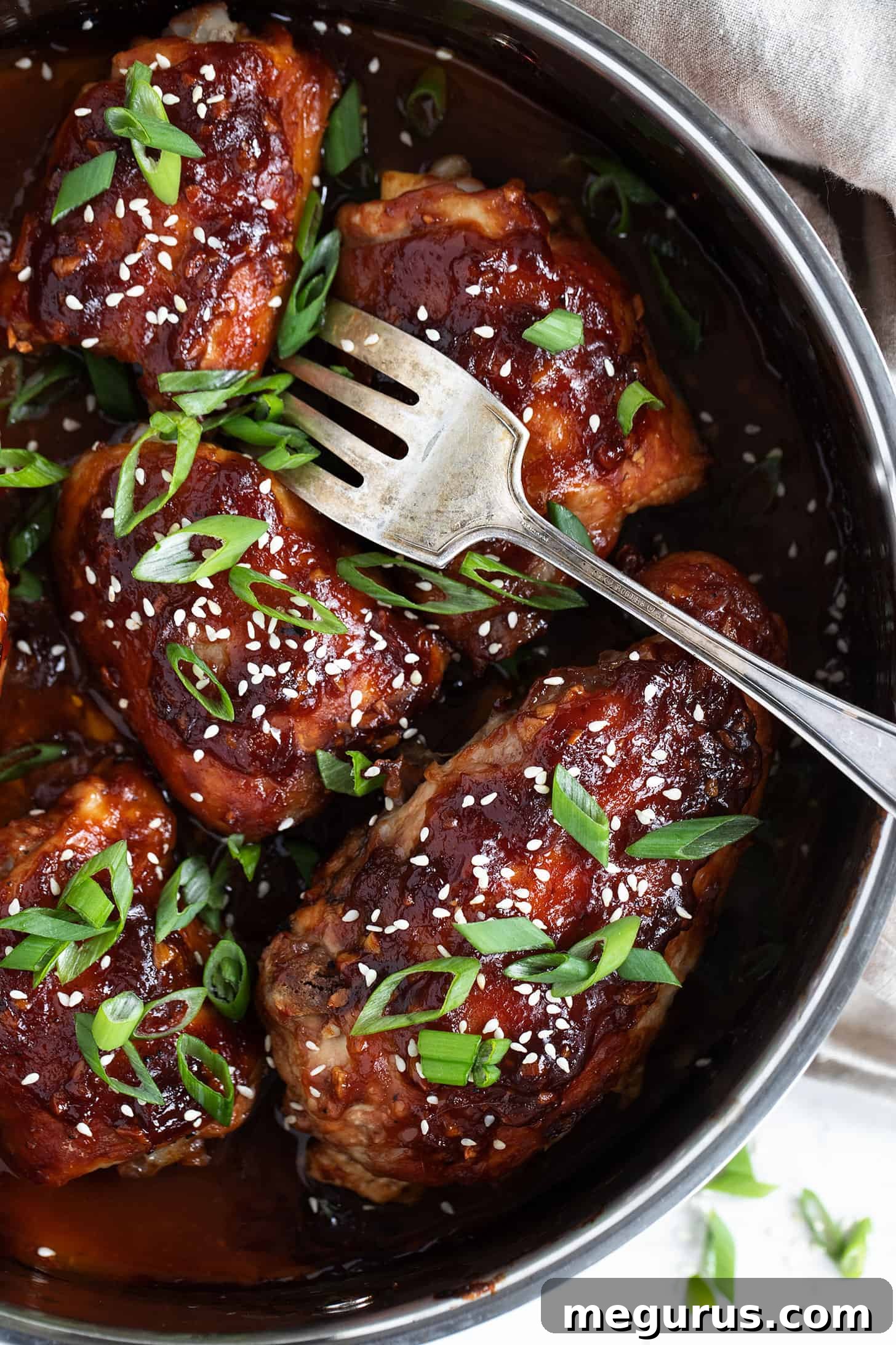 Close-up of sticky chicken with a fork, showing the caramelized glaze.