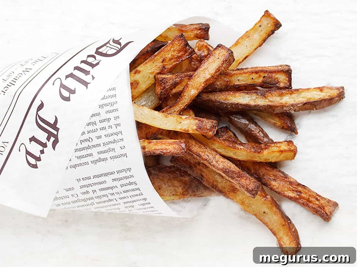 perfect air fryer fries wrapped in newspaper wrap, golden and crispy