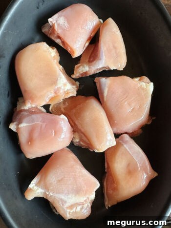 Chicken pieces arranged in a baking dish, ready for sauce