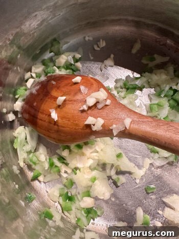 Onion and jalapeño softening in the pan