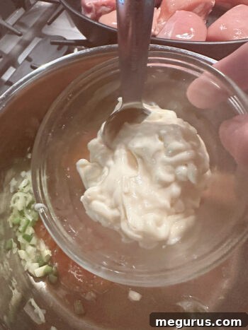 Mayonnaise being stirred into the sauce ingredients