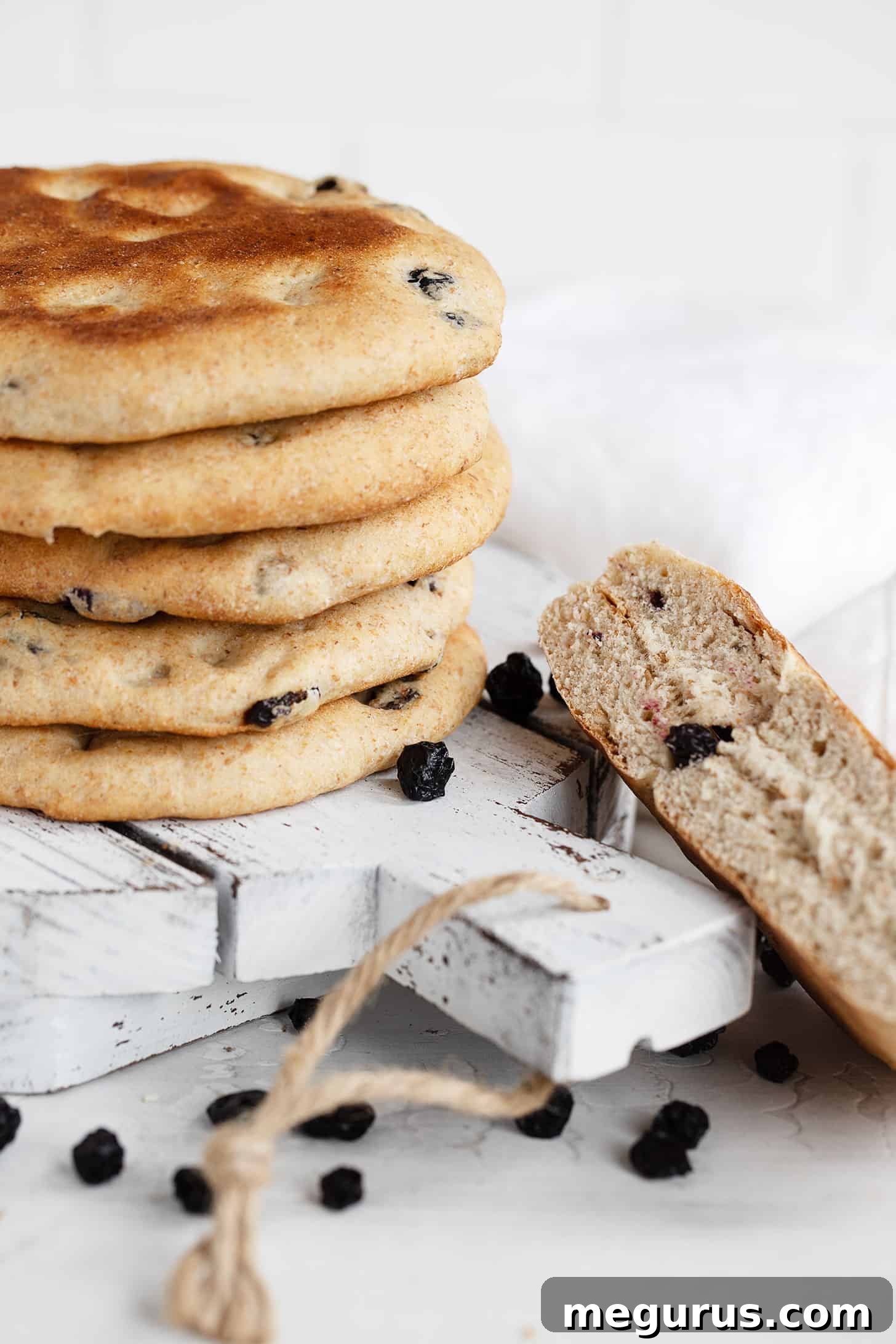 Delicious blueberry breakfast rounds stacked and one cut in half to show the fruit inside.