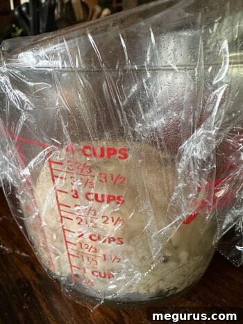Dough rising in a large measuring cup, indicating it has doubled in size.
