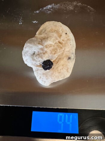 Dough being divided into equal pieces using a kitchen scale for precision.