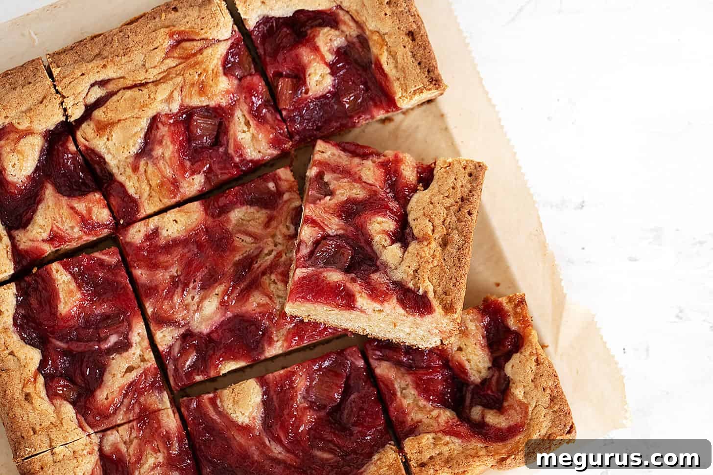 Delicious rhubarb blondies cut into squares on parchment paper