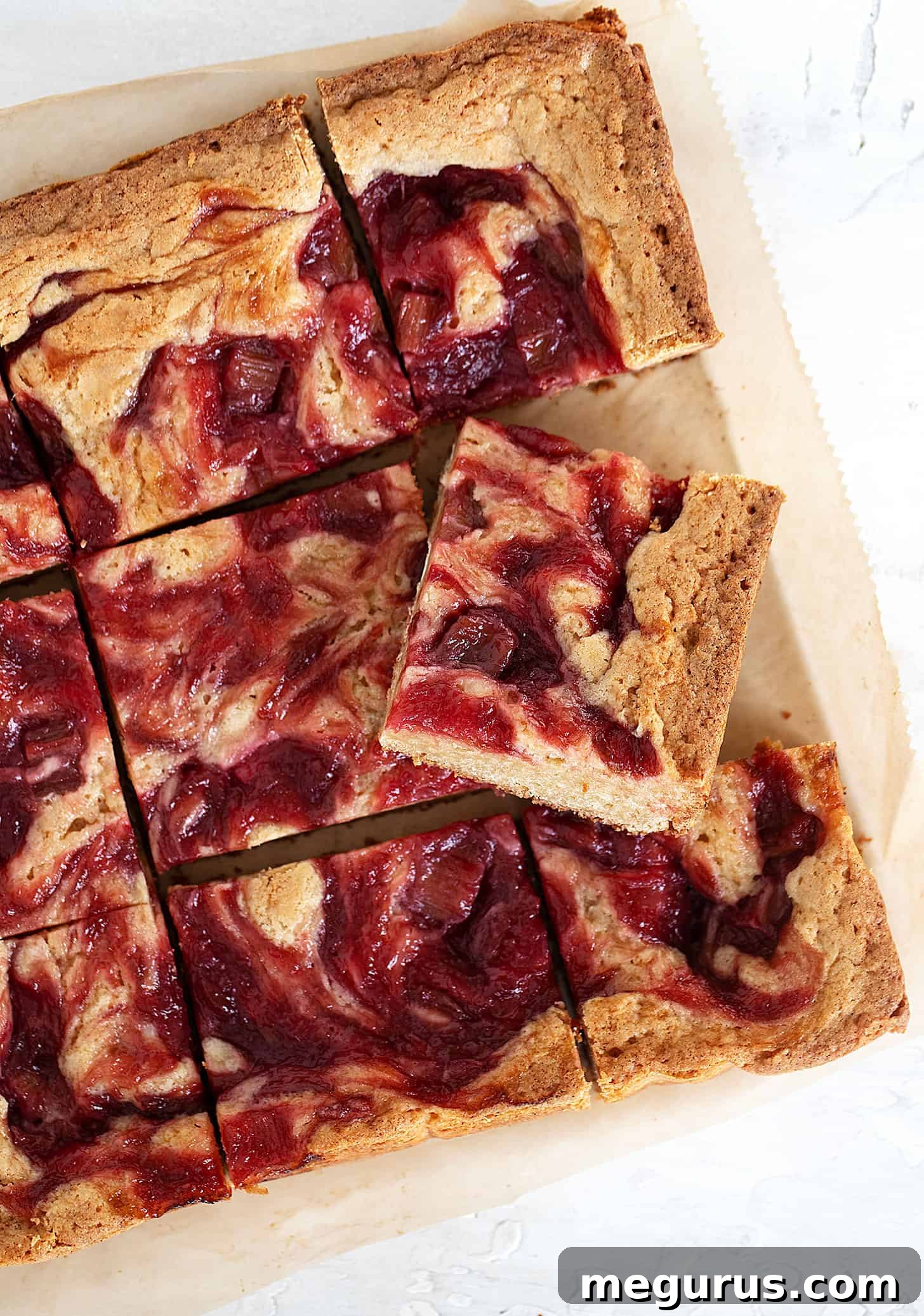 Rhubarb blondies cut into perfect squares on parchment paper