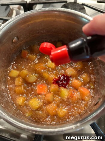 Red food coloring being added to the rhubarb compote