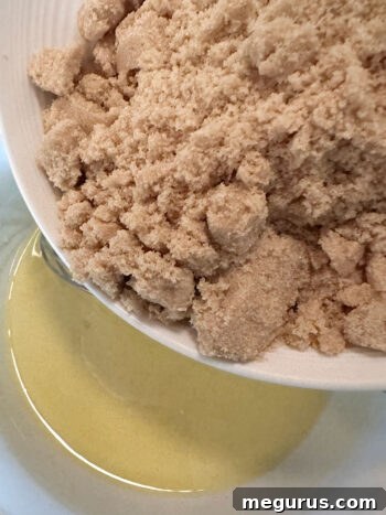 Adding brown sugar to melted butter in a bowl