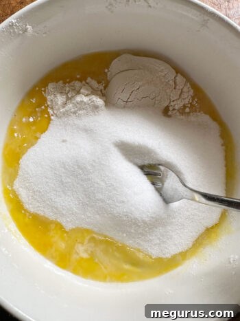 Bowl containing the mixed custard filling ingredients: eggs, flour, and sugar.