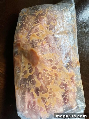 Chicken thighs being tossed with the miso marinade in a zipper bag.