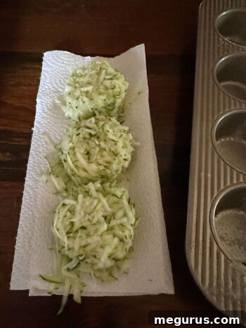 Shredded zucchini draining on paper towel to remove excess moisture.
