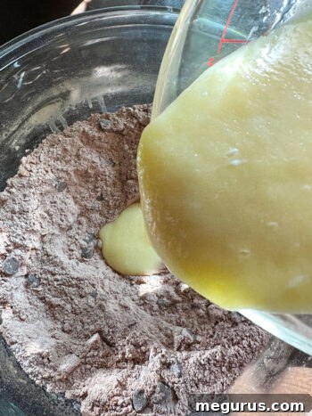 Mixing wet ingredients into the dry muffin batter.