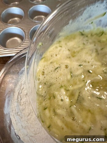 Pouring the wet ingredient mixture into the bowl of dry ingredients.