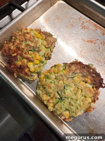 A cooked fritter placed on a baking sheet, ready to be kept warm in the oven.