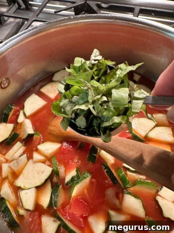 adding fresh basil to soup