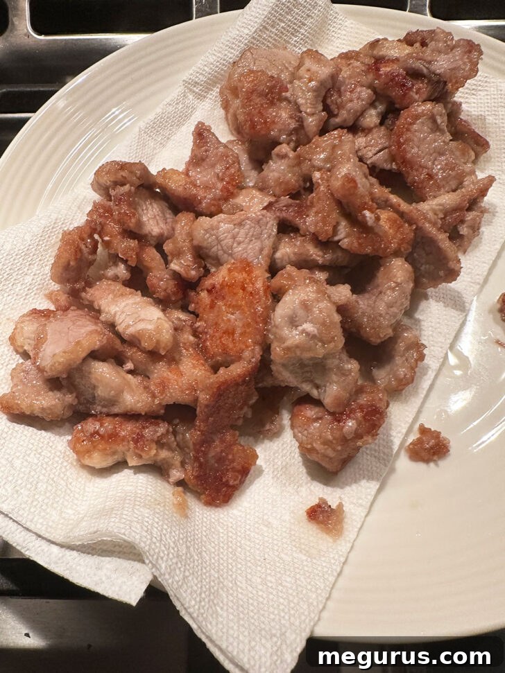 Cooked Mongolian pork strips removed from skillet and resting on a plate