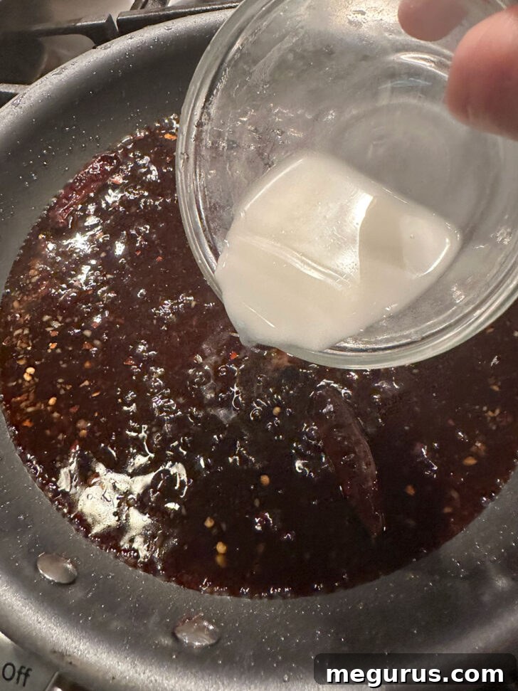 Thickening the Mongolian sauce in a skillet with a cornstarch slurry