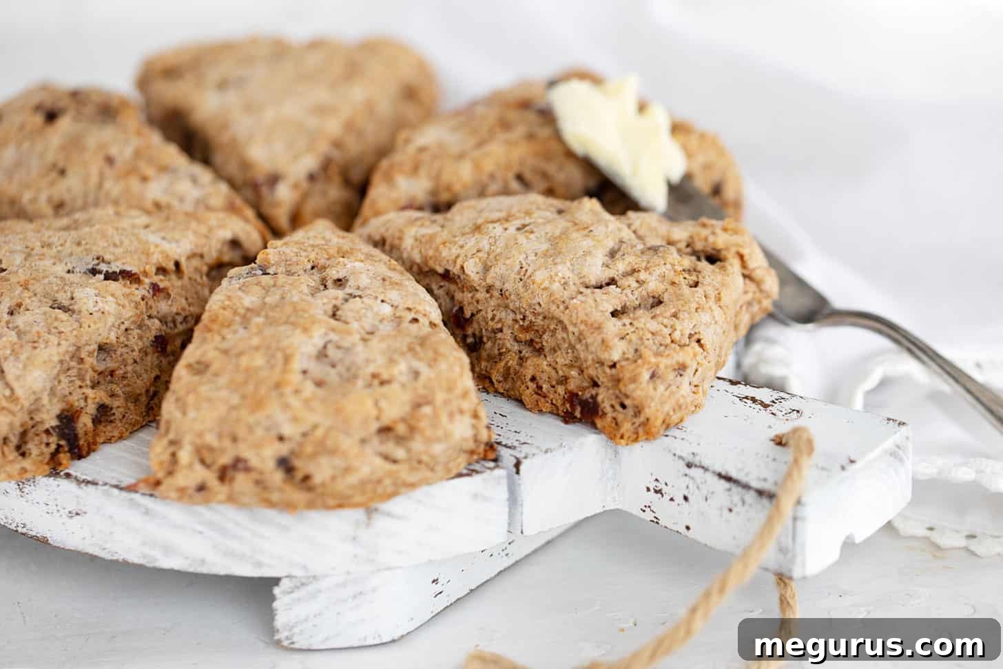 date scones with buttermilk on serving board with knife and butter