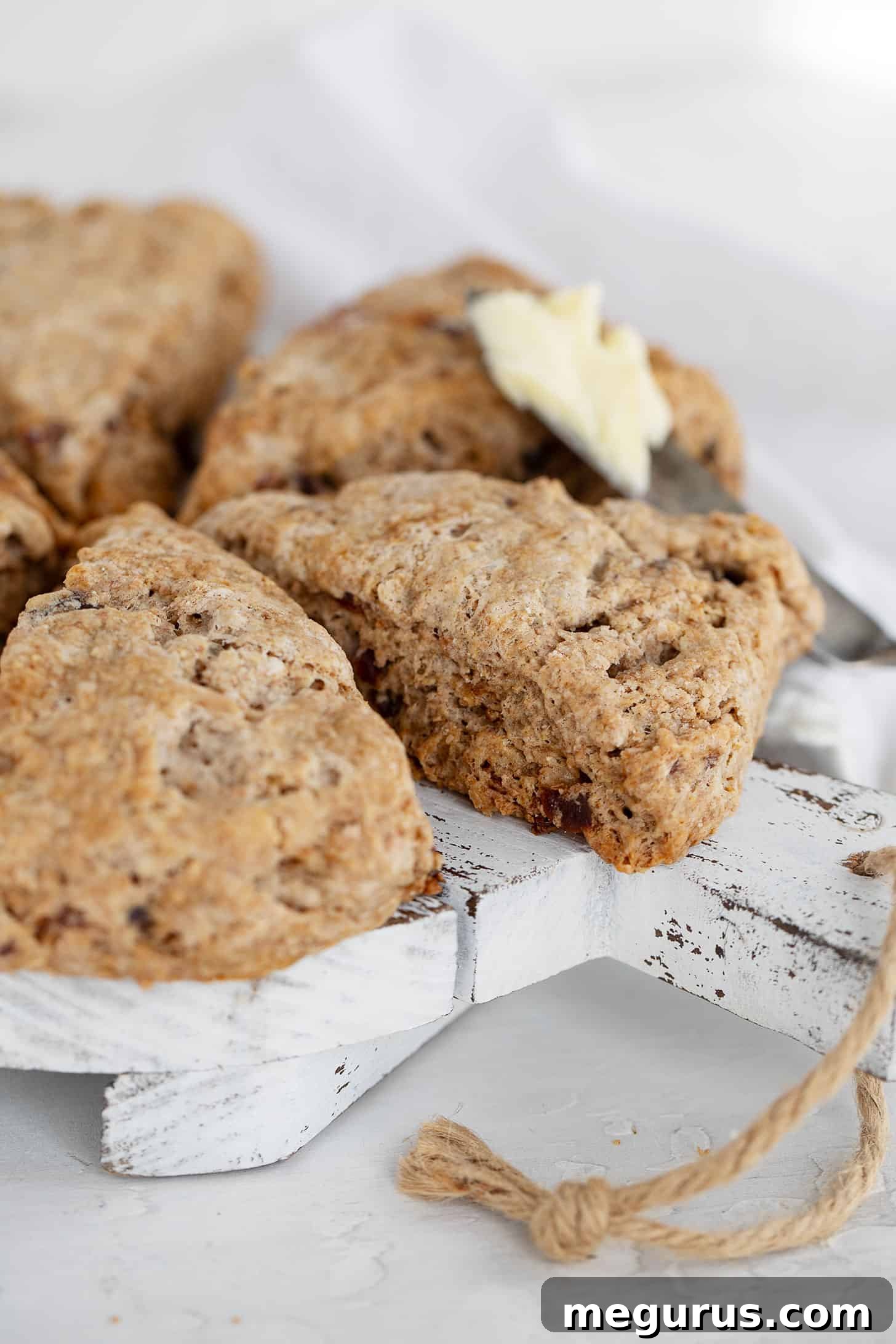 date scones on serving board with knife and butter