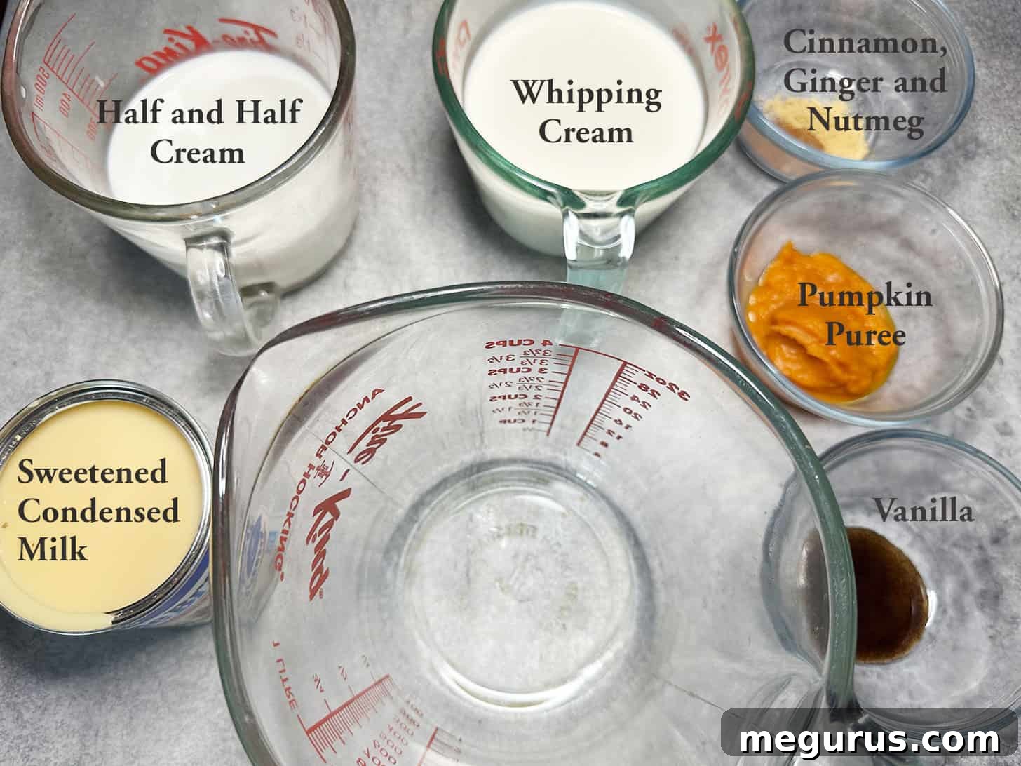Essential ingredients laid out for making pumpkin spice coffee creamer at home: sweetened condensed milk, heavy cream, half and half, pumpkin puree, and spices.