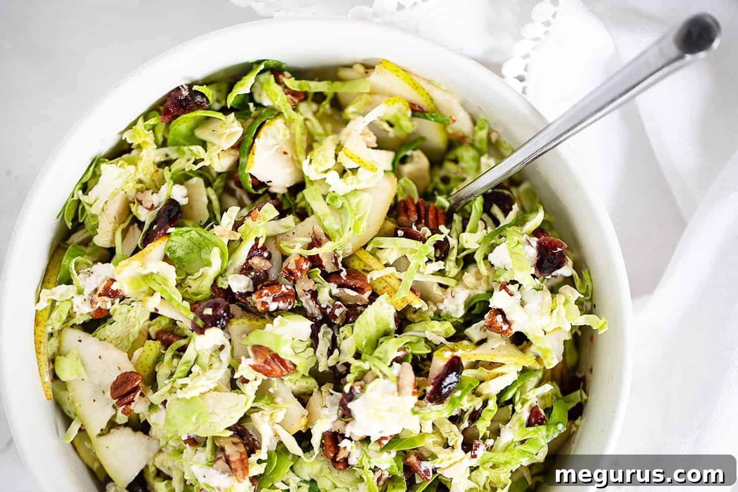Brussels Sprouts and pear salad in bowl with spoon