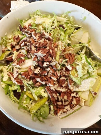 adding toasted pecans to bowl